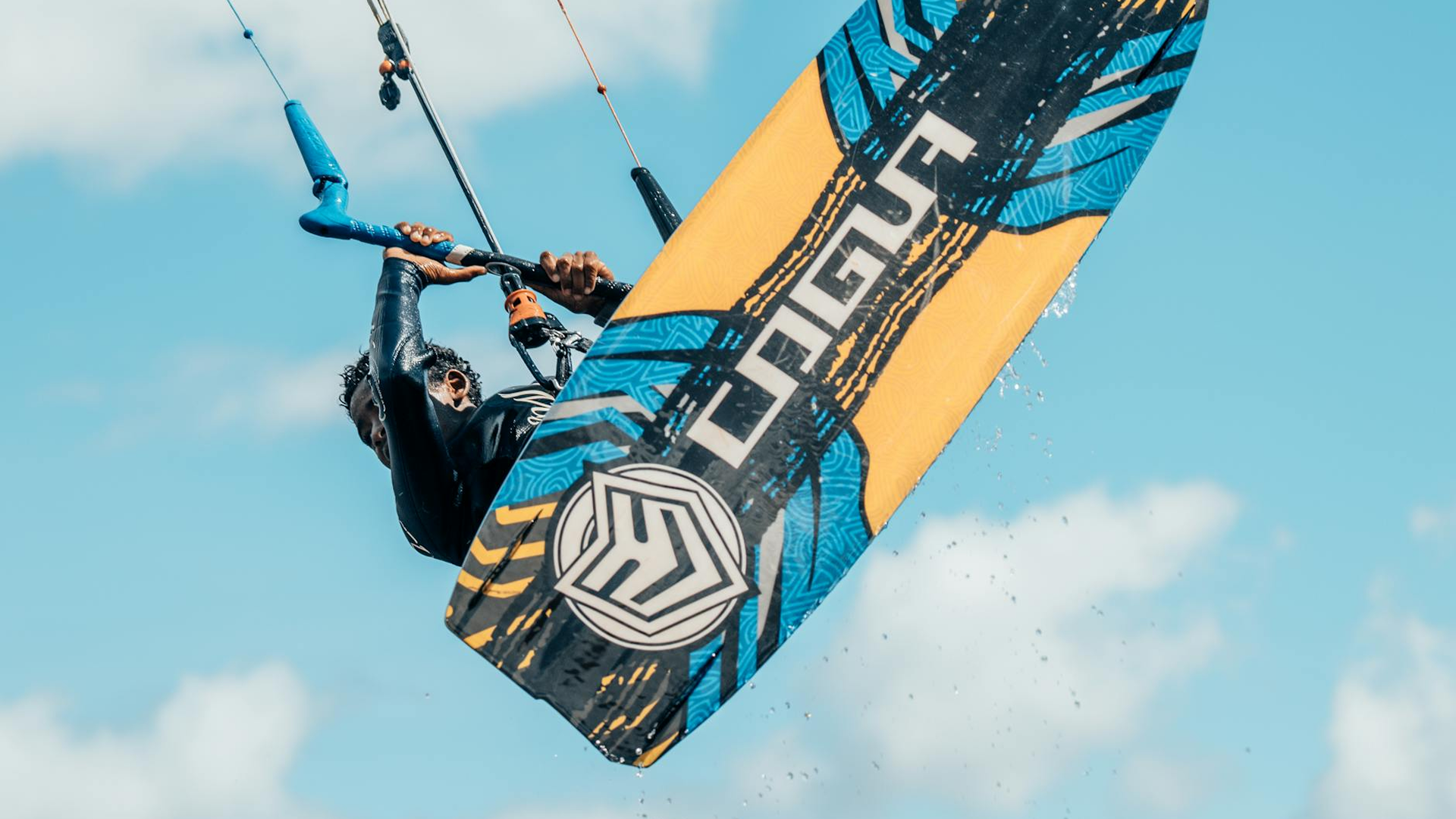 Kiteboarder foilboarding over calm water during a light-wind session at sunset